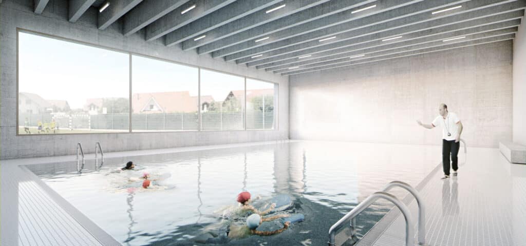 von KGRUPPE Architekten Basel - Ein Schwimmlehrer überwacht Kinder, die in einem Hallenbad schwimmen, dabei sieht man durch grosse Fenster im Hintergrund Häuser und spielende Kinder draussen.