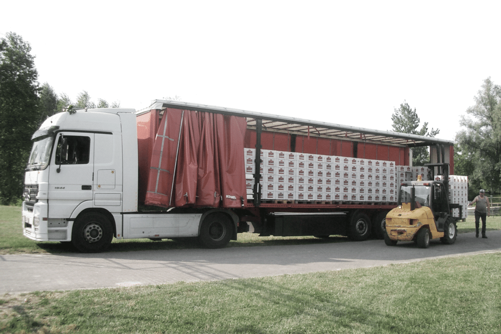 Szenografie, Umnutzung und Upcycling von KGRUPPE Architekten Basel - Ein LKW mit geöffnetem Seitenvorhang wird von einem Gabelstapler beladen.