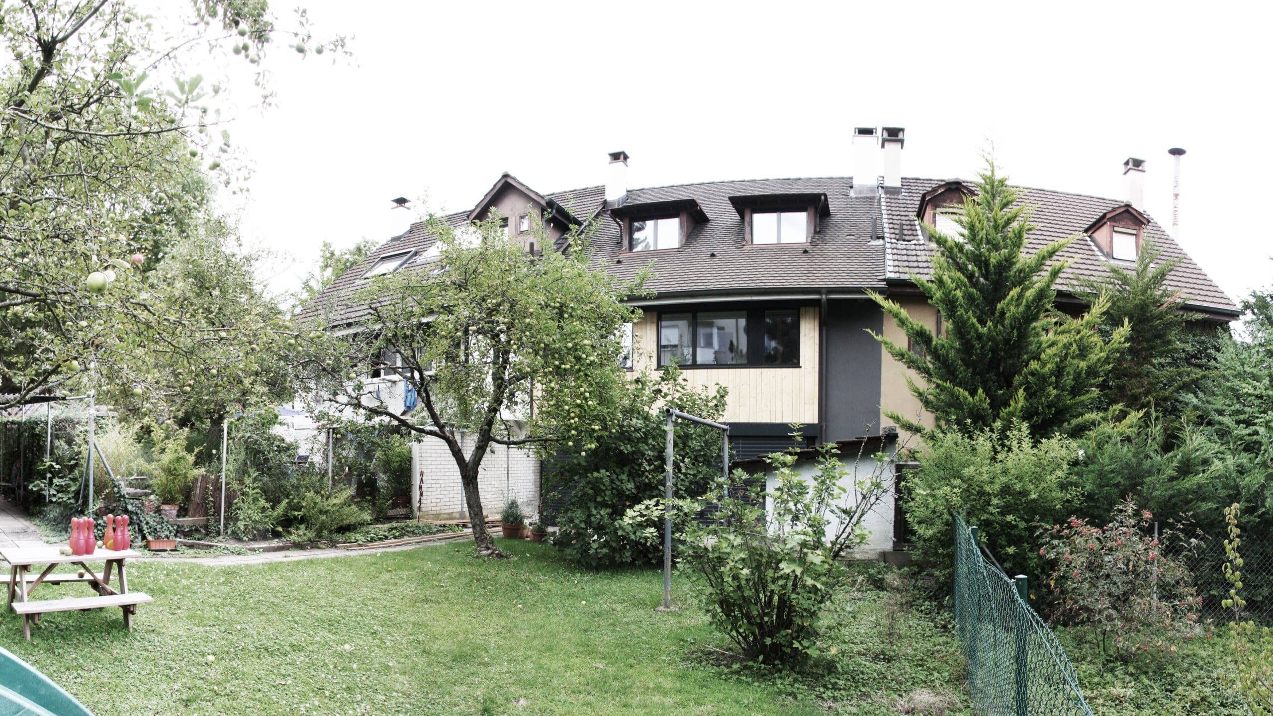 von KGRUPPE Architekten Basel - Wohnhaus mit Garten und Obstbäumen im Vordergrund.